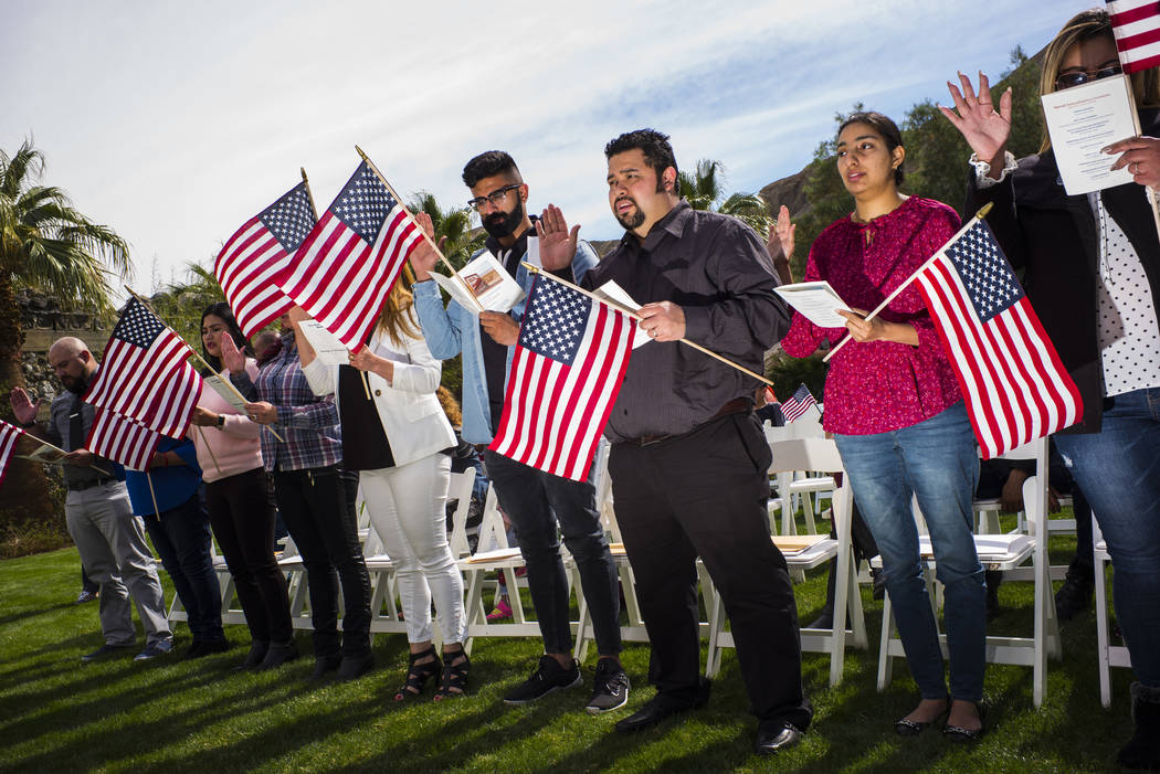 Attendees, including Raul Vargas, center, and Mandeep Kaur, right, participate in the oath of allegiance during a naturalization ceremony at the Mission Gardens at The Inn at Death Valley in Death ...