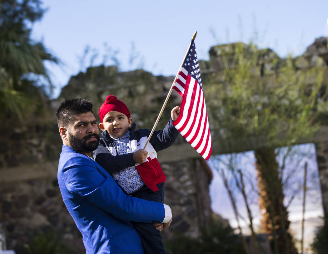 Pardeep Singh, of Bakersfield, Calif., carries his nephew, Gurman Singh, 2, before a naturalization ceremony at the Mission Gardens at The Inn at Death Valley in Death Valley National Park, Calif. ...