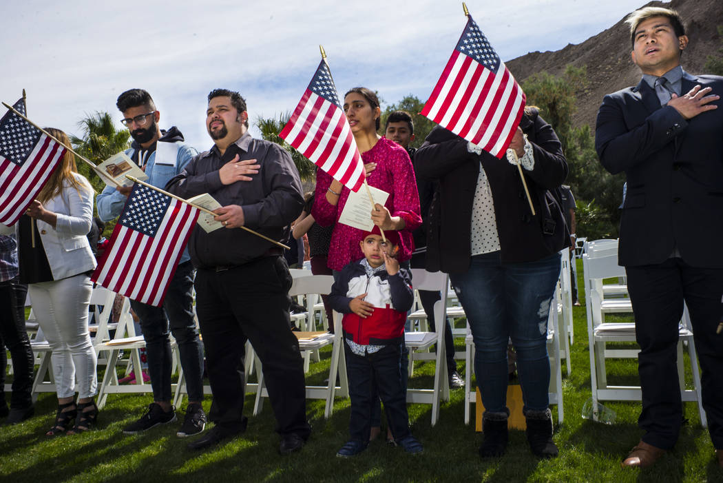 Gurman Singh, 2, center, stands with his mother, Mandeep Kaur, of Bakersfield, Calif., originally from India, as attendees recite the pledge of allegiance during a naturalization ceremony at the M ...