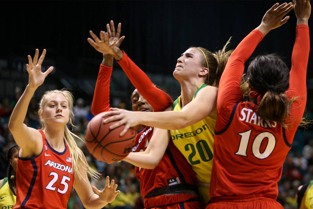 Oregon Ducks guard Sabrina Ionescu (20) pushes through Arizona Wildcats forward Destiny Graham (21) and Arizona Wildcats forward Tee Tee Starks (10) with the ball during the second half of an NCAA ...