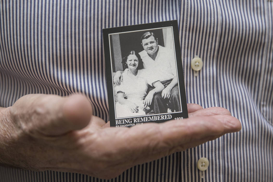 Tom Stevens, the grandson of Babe Ruth, holds a commemorative card showing his mother Julia Ruth Stevens, left, with her father Babe Ruth, on Thursday, Jan. 31, 2019, at Stevens' home, in the Las ...