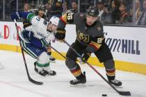 Vegas Golden Knights center Paul Stastny (26) looks to pass the puck as Vancouver Canucks defenseman Ben Hutton (27) trails behind during the third period of an NHL hockey game at T-Mobile Arena i ...