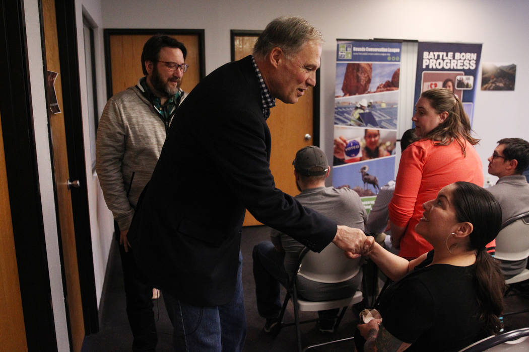 Washington Gov. Jay Inslee, left, a Democratic presidential candidate, shakes hands with Fawn Douglas, after speaking on climate change at the Nevada Conservation League offices in Las Vegas, Satu ...