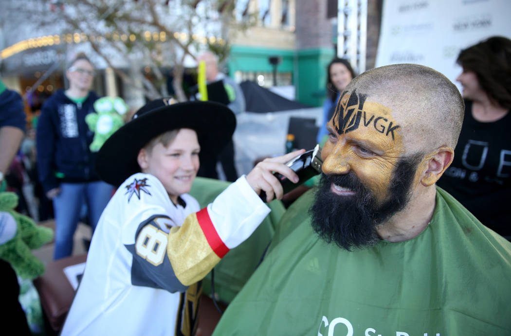 John McManus of Las Vegas gets his beard shaved by son Peter McManus, 11, during St. Baldrick's Foundation shave-a-thon on the Brooklyn Bridge at New York-New York in Las Vegas, Saturday, March 9, ...