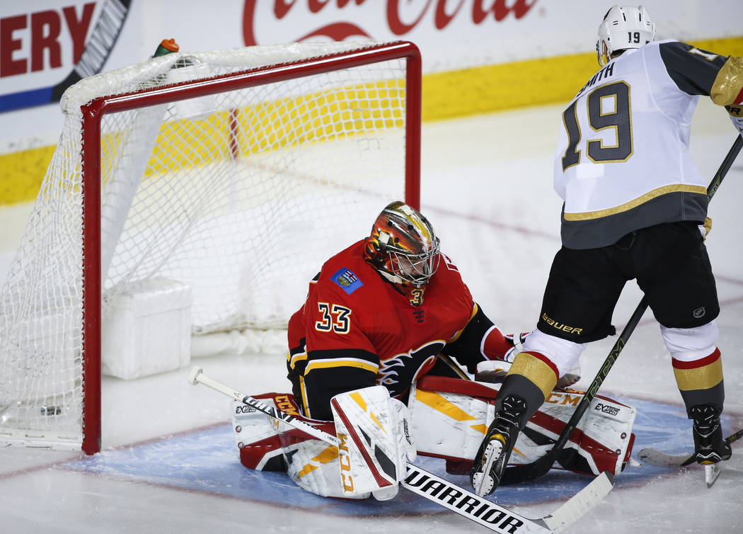 Vegas Golden Knights' Reilly Smith, right, scores on Calgary Flames goalie David Rittich, of the Czech Republic, during second period NHL hockey action in Calgary, Alberta, Sunday, March 10, 2019. ...