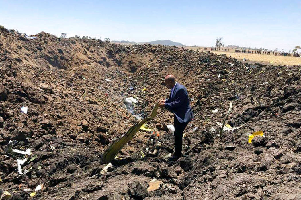In this photo taken from the Ethiopian Airlines Facebook page, the CEO of Ethiopian Airlines, Tewolde Gebremariam, looks at the wreckage of the plane that crashed shortly after takeoff from Addis ...
