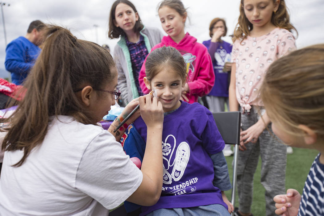 Julissa Toruno paints the face of Sheina Shomer, 5, during Friendship Circle's Walk4Friendship Las Vegas event at Las Vegas Sports Park, Sunday, March 10, 2019. Friendship Circ ...
