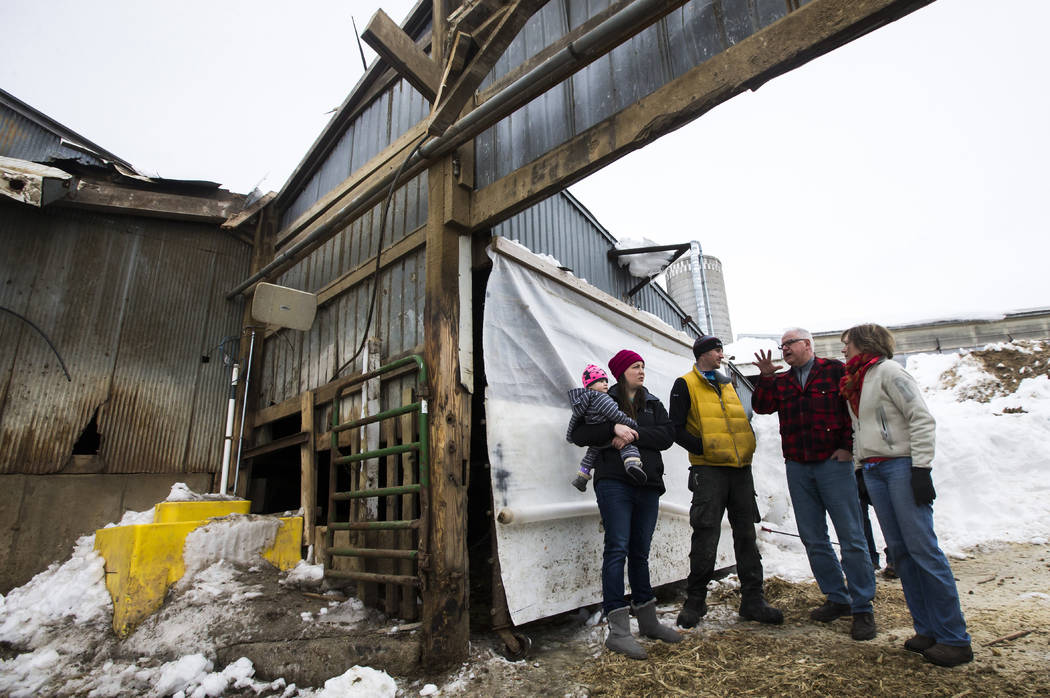 Minnesota Gov. Tim Walz, second from right, and U.S. Sen. Tina Smith, right, talk with Katie and Rob Kreidermacher while looking at a damaged barn during a visit to the Kreidermacher's farm, Satur ...