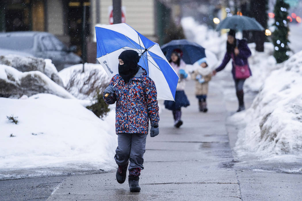 Ten-year-old Connor Chan made his way in the rain down Hennepin Avenue in Minneapolis, Saturday, March 9, 2019. The National Weather Service issued winter storm watches and warnings for a wide swa ...
