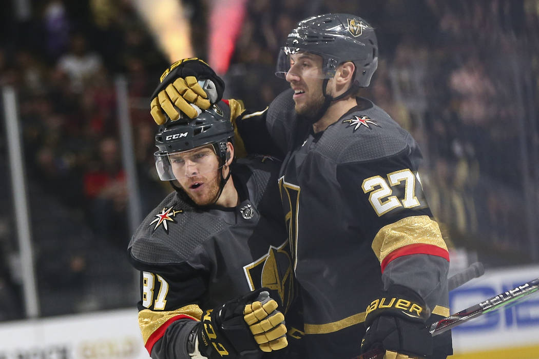 Golden Knights defenseman Shea Theodore (27) celebrates his goal with Golden Knights center Jonathan Marchessault (81) during the first period of an NHL hockey game against the Calgary Flames at T ...