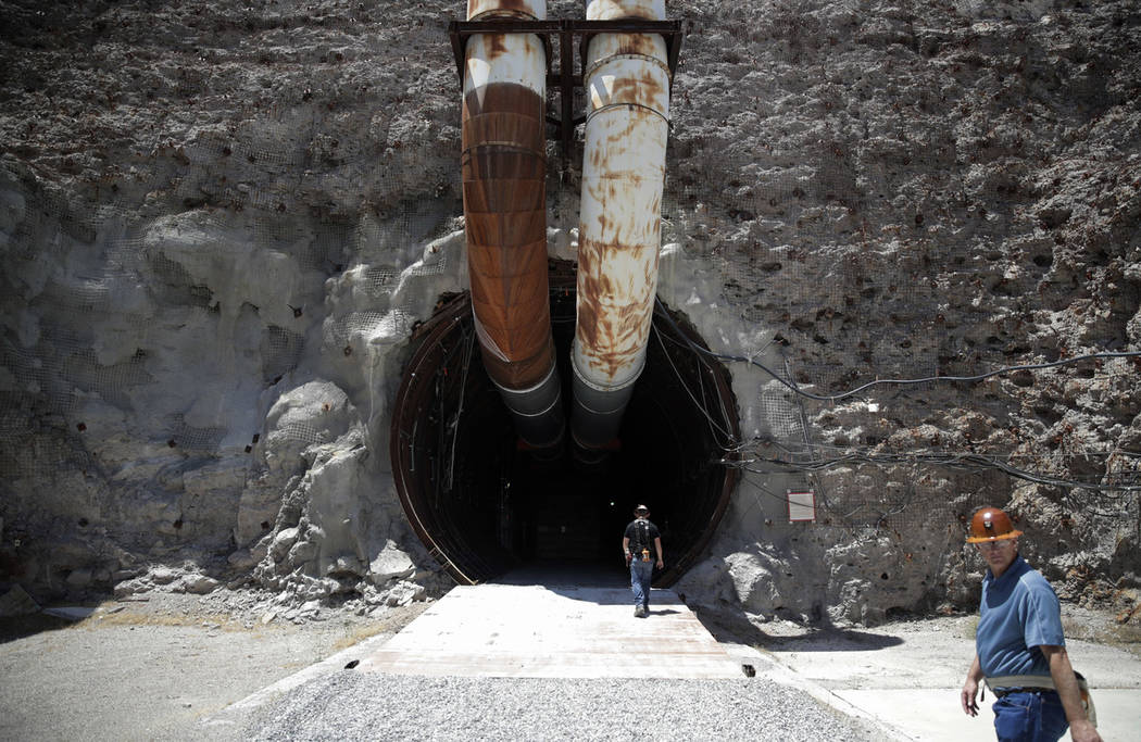 People walk into the north portal of Yucca Mountain during a congressional tour Saturday, July 14, 2018, near Mercury, Nev. Several members of Congress toured the proposed radioactive waste dump 9 ...