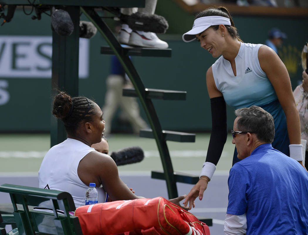 Garbine Muguruza, of Spain, right, speaks with Serena Williams, left, during their match at the BNP Paribas Open tennis tournament Sunday, March 10, 2019, in Indian Wells, Calif. Williams retired ...