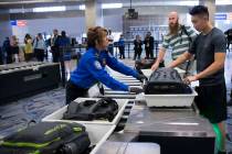 Transportation Security Administration agent Donna Franco, left, assists a passenger in one of the new automated screening lanes at McCarran International Airport Terminal 1 in Las Vegas, Aug. 31, ...