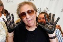 In this June 25, 2008, file photo, Hal Blaine holds up his hands covered in cement after placing them in wet cement with Don Randi and Glen Campbell, representing The Wrecking Crew following an in ...