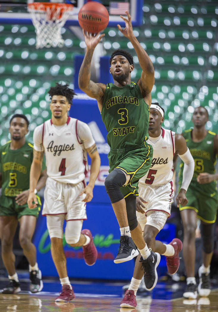 Chicago State sophomore guard Travon Bell (3) sprints up court past New Mexico State senior guard JoJo Zamora (4) and guard Clayton Henry (5) to try and beat the clock at the end of the first half ...