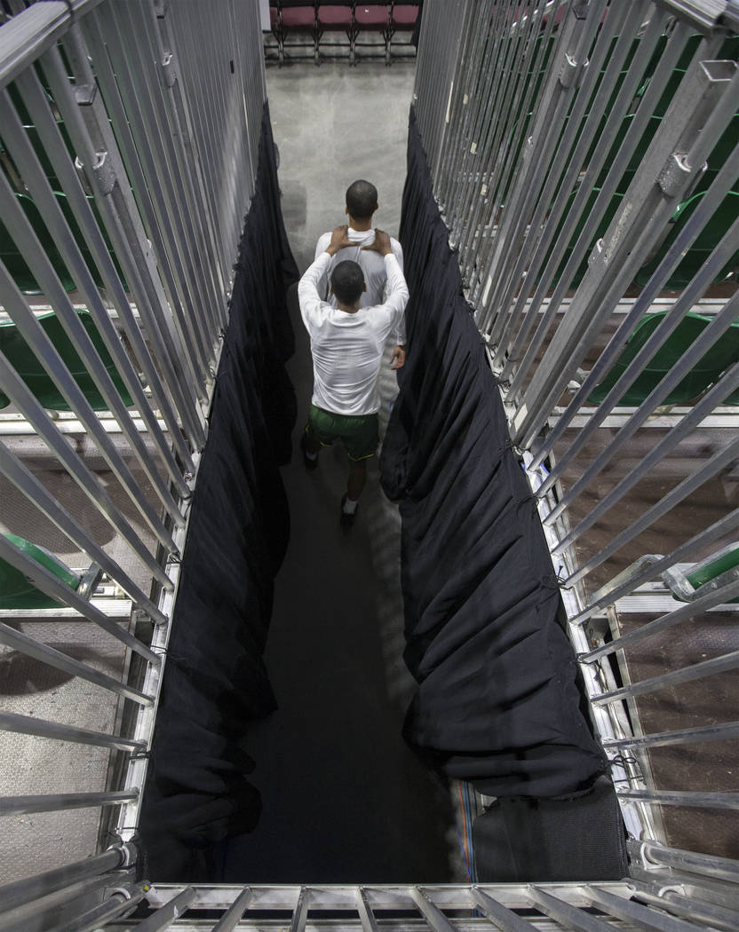 Chicago State sophomore center Noah Bigirumwami, bottom, encourages teammate Delshon Strickland as they walk out of the tunnel before the start of the Cougars opening round Western Athletic Confer ...