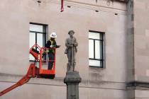 A workman prepares a Confederate staute for removal, Tuesday, March 12, 2019, in Winston-Salem, N.C. Crews began removing the Confederate statue Sunday from the grounds of an old courthouse. North ...
