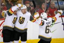 Vegas Golden Knights' Mark Stone, center, celebrates his goal with teammates during second period NHL hockey action against the Calgary Flames in Calgary, Alberta, Sunday, March 10, 2019. (Jeff Mc ...