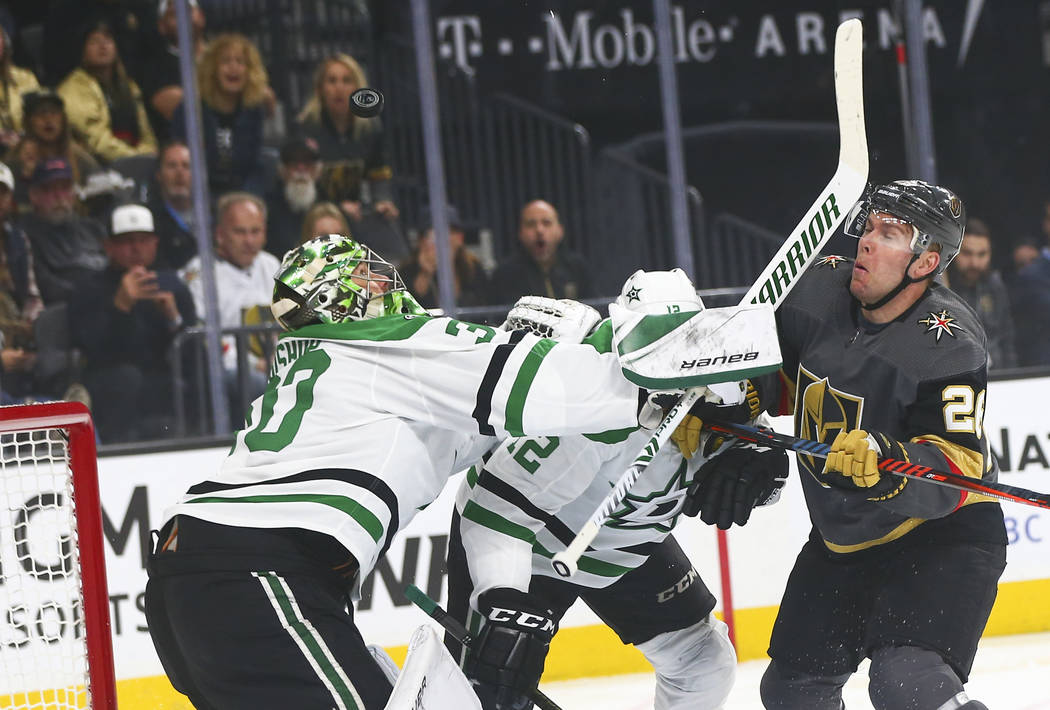 Dallas Stars goaltender Ben Bishop (30) watches the puck while Golden Knights center Paul Stastny, right, gets hit in the face with a stick during the first period of an NHL hockey game at T-Mobil ...