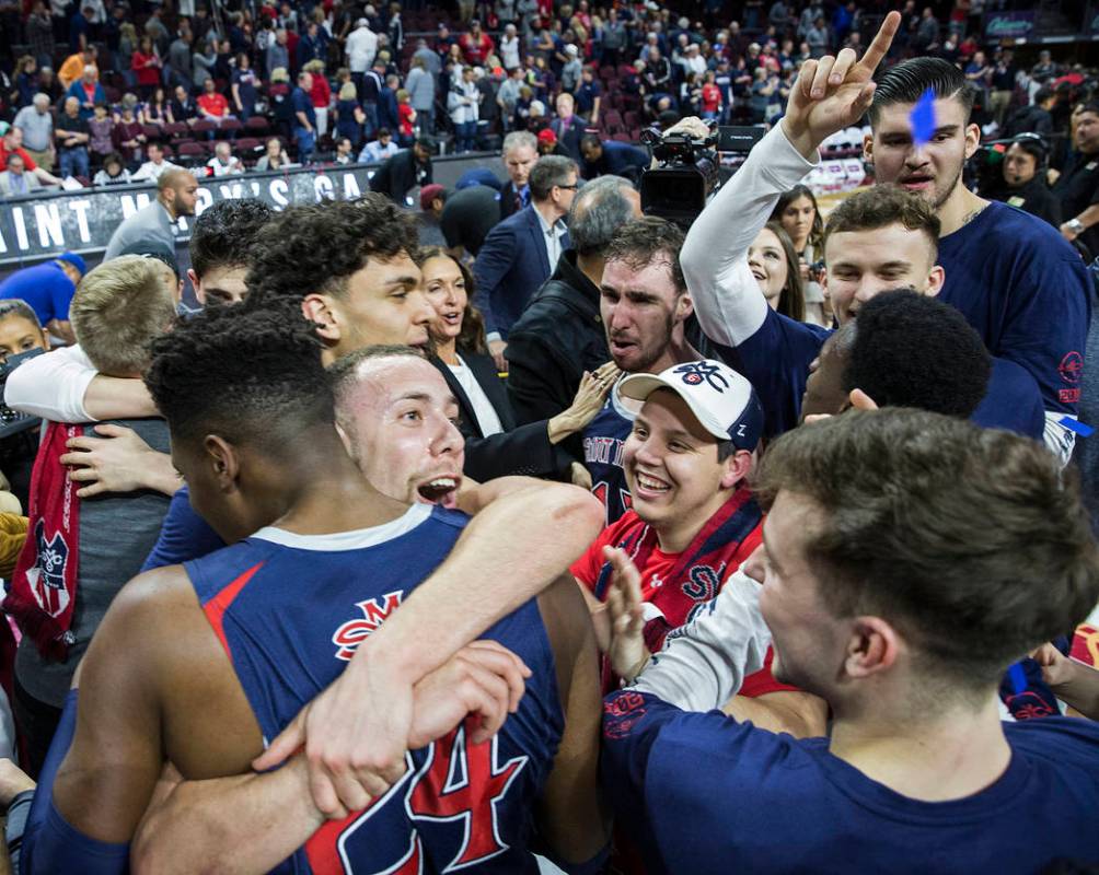 St. Mary's junior guard Jordan Ford, left/top, gets a big hug from sophomore forward Malik Fitts (24) after the Gaels upset Gonzaga 60-47 to win the West Coast Conference championship on Tuesday, ...