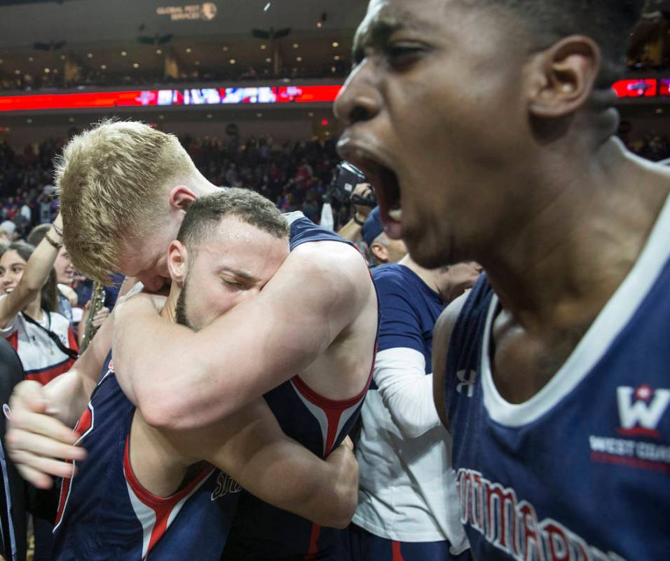 St. Mary's junior guard Jordan Ford, left, gets a big hug from teammate Matthias Tass while sophomore forward Malik Fitts, right, celebrates after the Gaels upset Gonzaga 60-47 to win the West Coa ...