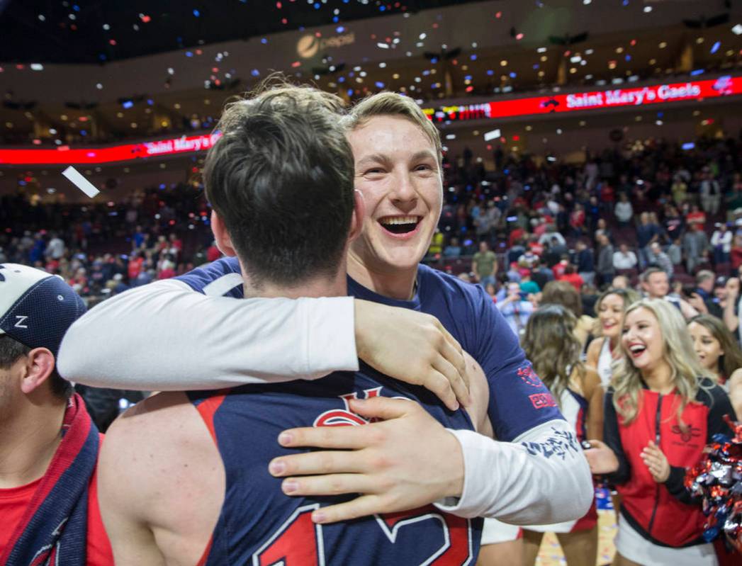 St. Mary's freshman guard Alex Mudronja gets a big hug from teammate Tommy Kuhse (12) after the Gaels upset Gonzaga 60-47 to win the West Coast Conference championship on Tuesday, March 12, 2019, ...