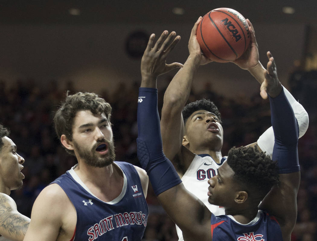 Gonzaga junior forward Rui Hachimura (21) grabs a rebound over St. Mary's sophomore forward Malik Fitts (24) and senior center Jordan Hunter (1) in the first half during the West Coast Conference ...