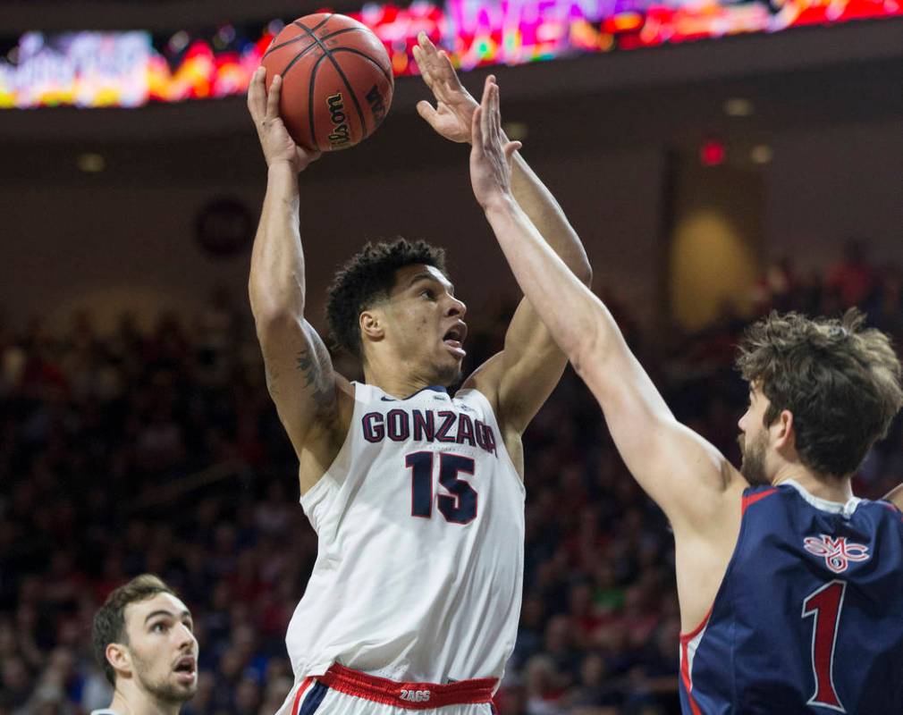 Gonzaga junior forward Brandon Clarke (15) drives past St. Mary's senior center Jordan Hunter (1) in the first half during the West Coast Conference finals game on Tuesday, March 12, 2019, at Orle ...