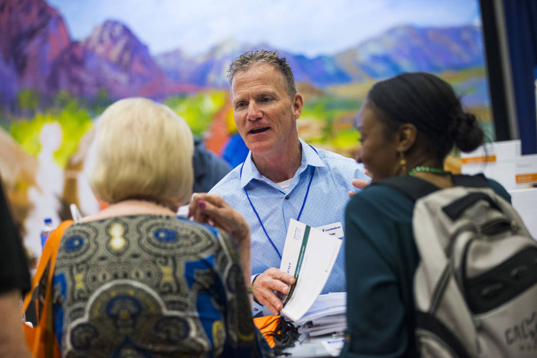 Daniel Hunter, a sales representative with UnitedHealthcare, talks with attendees during the fifth annual AgeWell Expo at the Rio Convention Center in Las Vegas on Saturday, March 16, 2019. (Chase ...