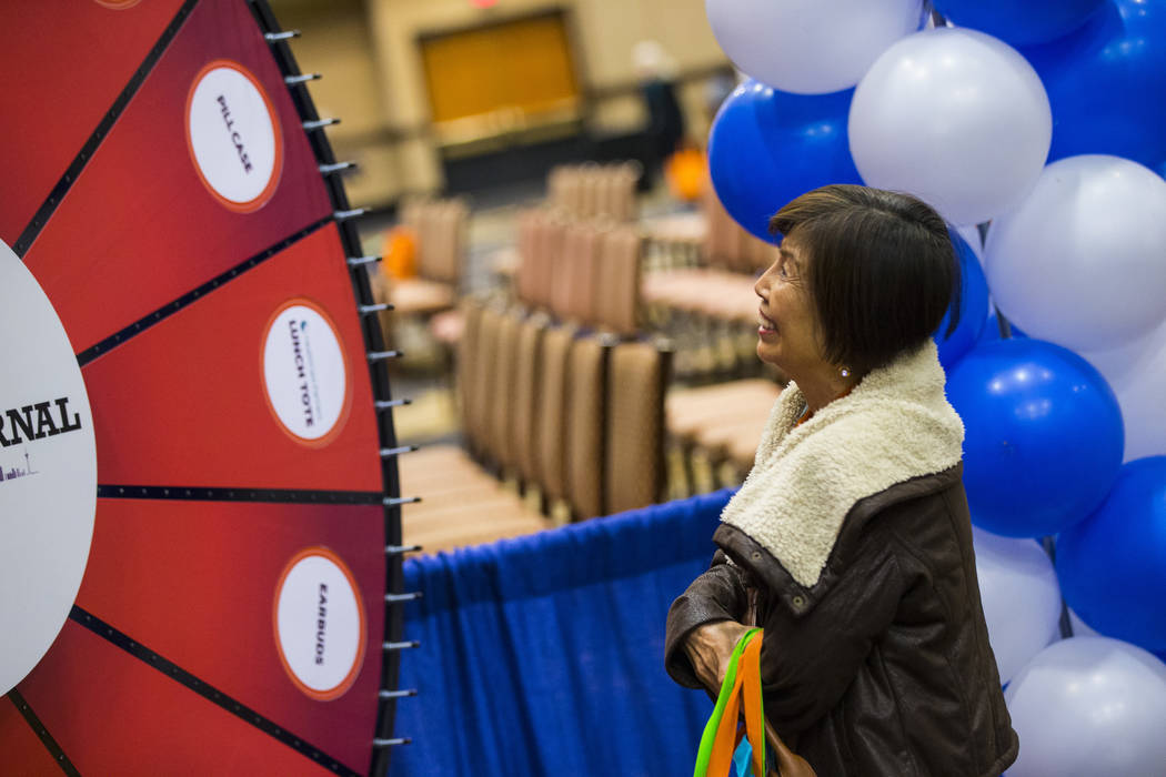 Lina Gozo of Henderson watches a wheel spin as part of a Review-Journal promotional giveaway during the fifth annual AgeWell Expo at the Rio Convention Center in Las Vegas on Saturday, March 16, 2 ...
