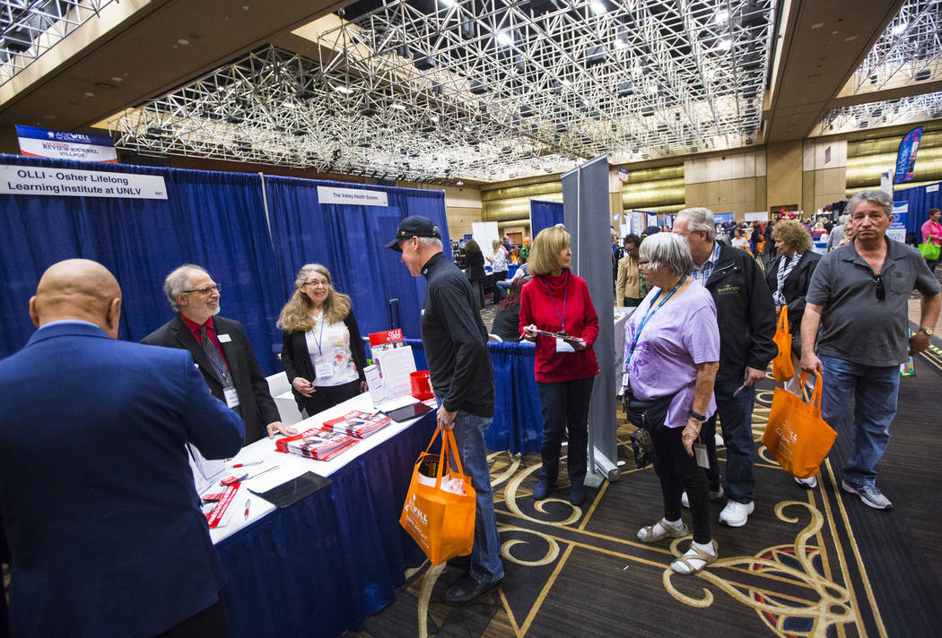 Robert Levrant, far left, director of the Osher Lifelong Learning Institute, or OLLI, at UNLV, talks with attendees during the fifth annual AgeWell Expo at the Rio Convention Center in Las Vegas o ...