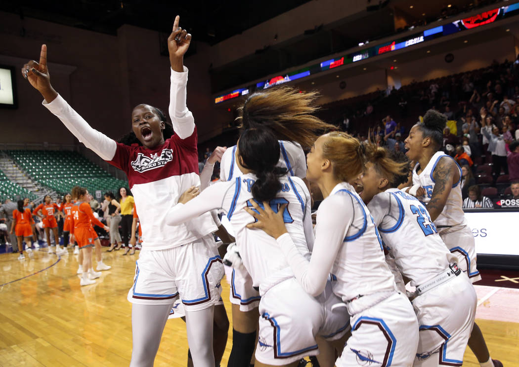 New Mexico State players celebrate after defeating Texas-Rio Grande Valley 76-73 in double overtime during an NCAA college basketball Western Athletic Conference Women's Tournament championship ga ...