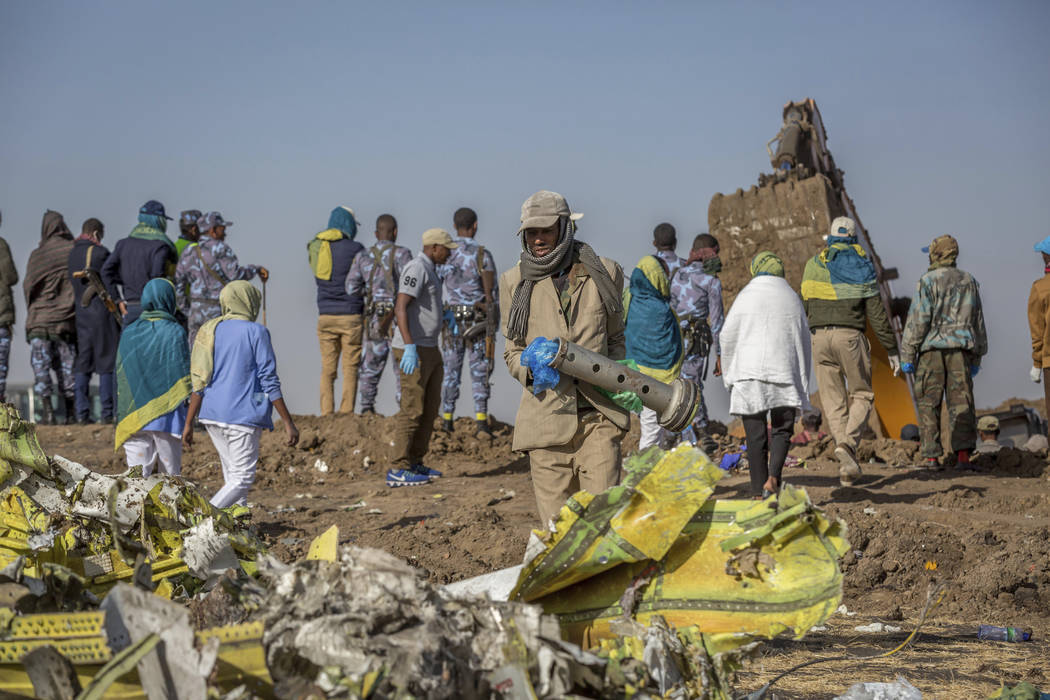 Workers gather at the scene of an Ethiopian Airlines flight crash near Bishoftu, or Debre Zeit, south of Addis Ababa, Ethiopia, Monday, March 11, 2019. (AP Photo/Mulugeta Ayene)