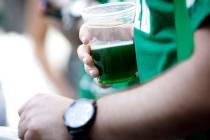 A reveler holds green beer at the Fremont Street Experience in downtown Las Vegas on Sunday, March 17, 2013. (Las Vegas Review-Journal/file)