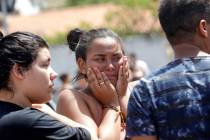 A student cries outside the Raul Brasil State School in Suzano, the greater Sao Paulo area, Brazil, Wednesday, March 13, 2019. The state government of Sao Paulo said two teenagers, armed with guns ...
