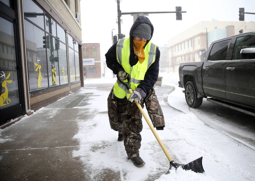 Ryan Bredensteiner of Top Flight Maintenance shovels Central Avenue during a blizzard on Wednesday, March 13, 2019, in Cheyenne. White-out conditions closed I-80, I-25, and U.S. 85, effectively cl ...