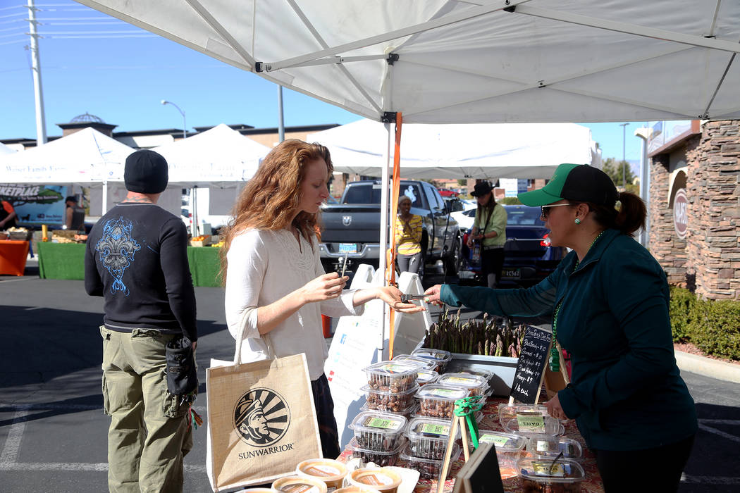 Carrie Hogan, founder of the Fresh52 farmers and artisans market, gives Sydney Ramsdell a sample of dates from China Ranch Date Farm at the Fresh52 farmers and artisans market in Las Vegas, Sunday ...