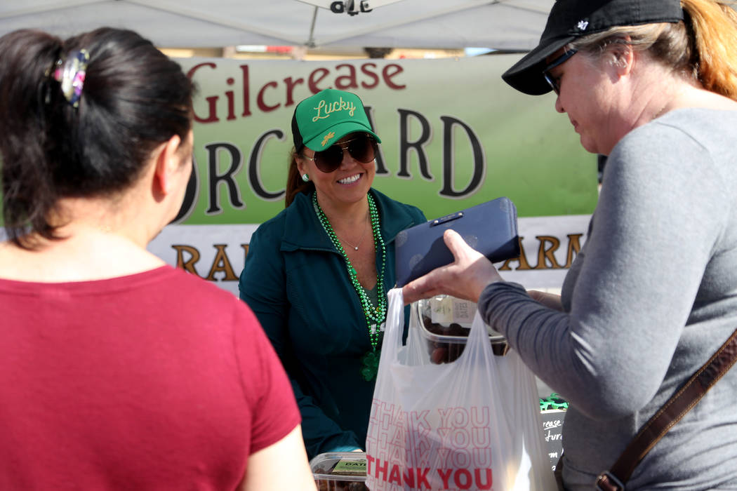 Carrie Hogan, founder of the Fresh52 farmers and artisans market, speaks to customers at a booth representing Gilcrease Orchard and China Ranch Date Farm at the Fresh52 farmers and artisans market ...