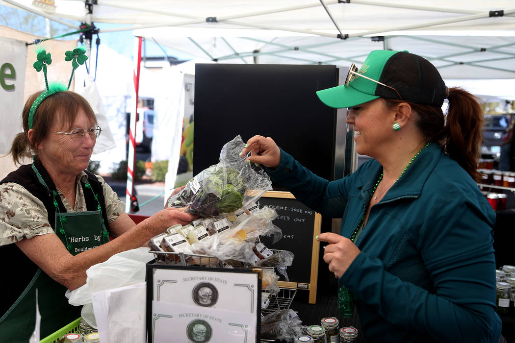 Diane Greene shows Carrie Hogan, founder of the Fresh52 farmers and artisans market, a sample of mustard greens at her booth Herbs by Diane at the Fresh52 farmers and artisans market in Las Vegas, ...