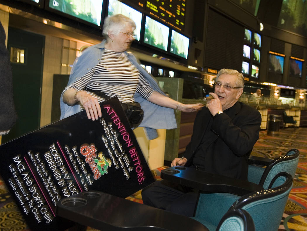 Twenty year patron Joyce Lindsay from Manitoba, Canada asks Bill Boyd, chairman of Boyd Gaming, to autograph a souvenir sign in the Stardust Race and Sports book shortly before the resort closed ...