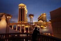 A man takes pictures of Caesars Palace in Las Vegas. (AP Photo/John Locher)