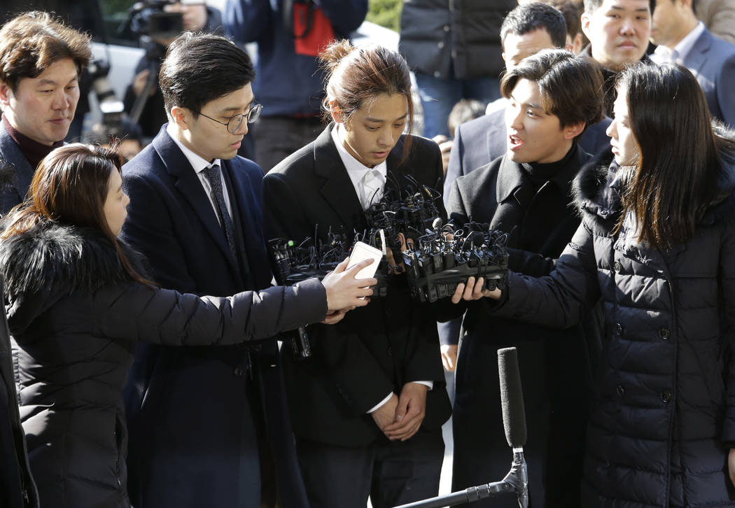 K-pop singer Jung Joon-young, center, arrives at the Seoul Metropolitan Police Agency in Seoul, South Korea, Thursday, March 14, 2019. Police have alleged Jung secretly filmed himself having sex w ...