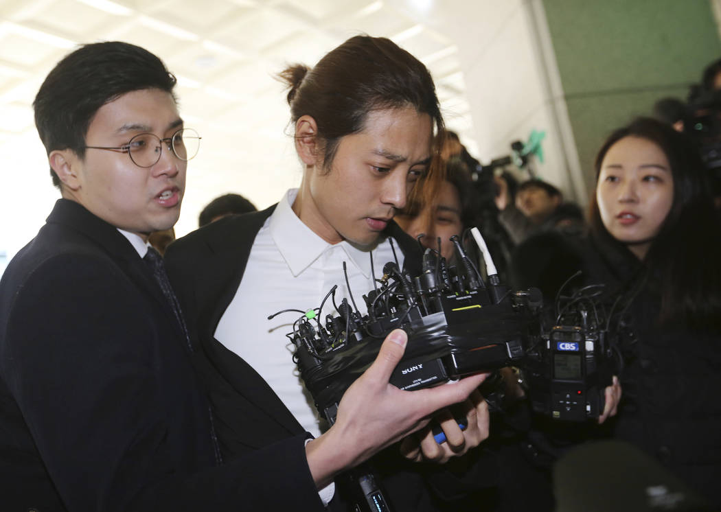 K-pop singer Jung Joon-young, center, arrives at the Seoul Metropolitan Police Agency in Seoul, South Korea, Thursday, March 14, 2019. Police have alleged Jung secretly filmed himself having sex w ...