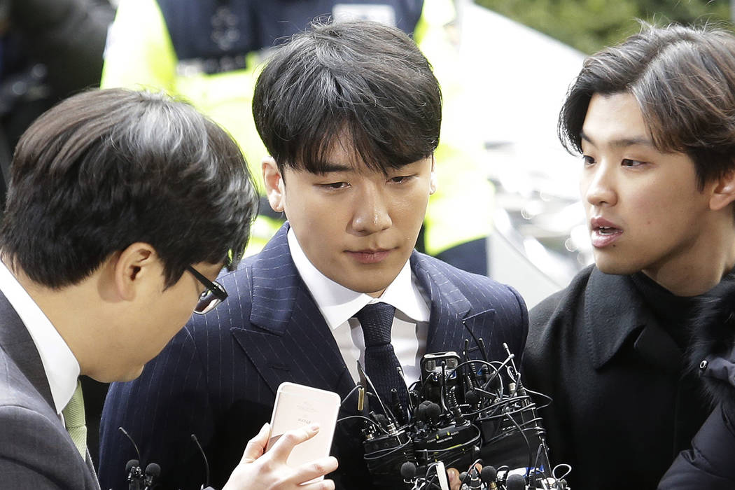 Seungri, center, member of a popular K-pop boy band Big Bang, arrives at the Seoul Metropolitan Police Agency in Seoul, South Korea, Thursday, March 14, 2019. After their stunning retirement annou ...