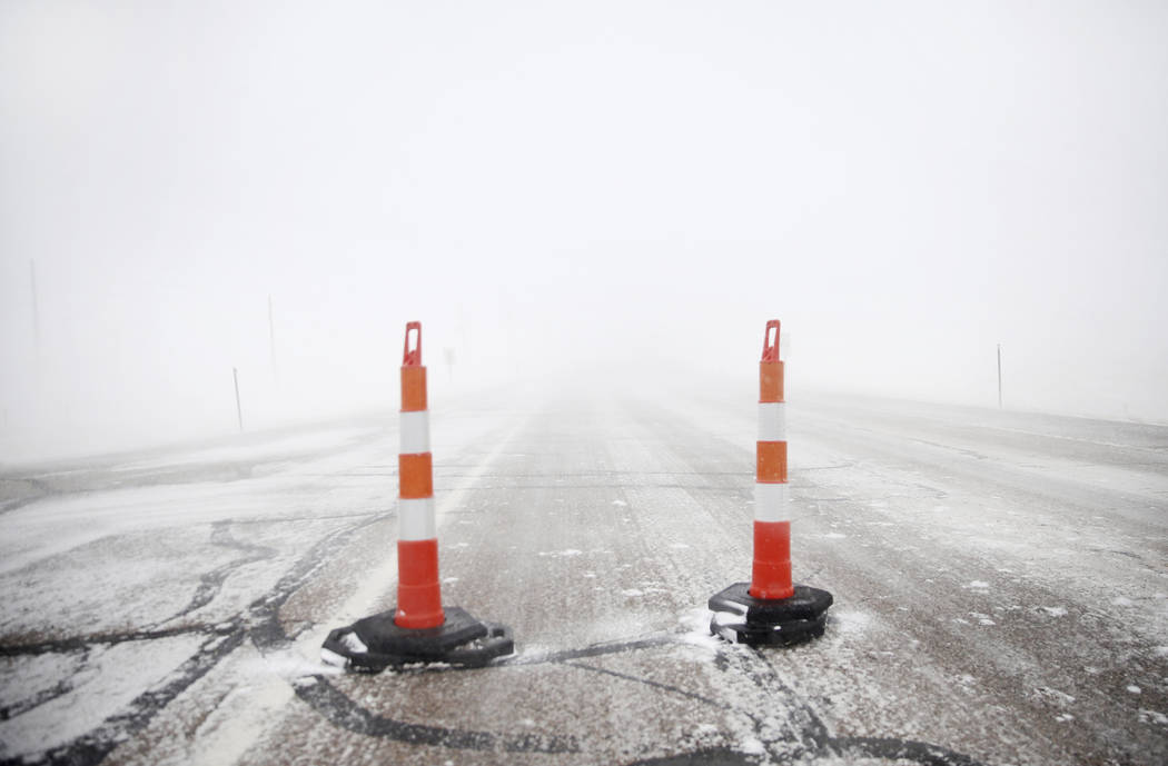 Cones block travel on Happy Jack Road during a blizzard on Wednesday, March 13, 2019, in Cheyenne, Wyo. White-out conditions closed I-80, I-25, and U.S. 85, effectively closing off the state capit ...