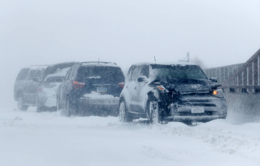 A string of wrecked vehicles sit on an overpass over Interstate 70 as a late winter storm packing hurricane-force winds and snow sweeps over the intermountain West Wednesday, March 13, 2019, in Au ...