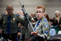 In this Jan. 28, 2013, file photo, firearms training unit Detective Barbara J. Mattson, of the Connecticut State Police, holds a Bushmaster AR-15 rifle, the same make and model used by Adam Lanza ...