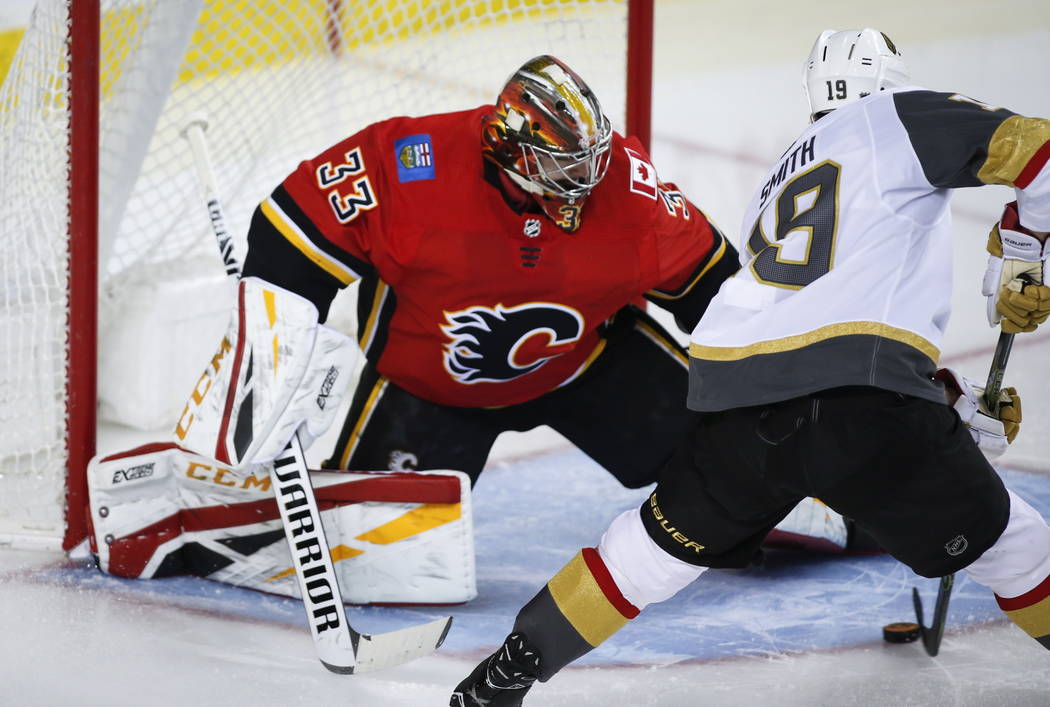 Vegas Golden Knights' Reilly Smith, right, scores on Calgary Flames goalie David Rittich, of the Czech Republic, during second period NHL hockey action in Calgary, Alberta, Sunday, March 10, 2019. ...