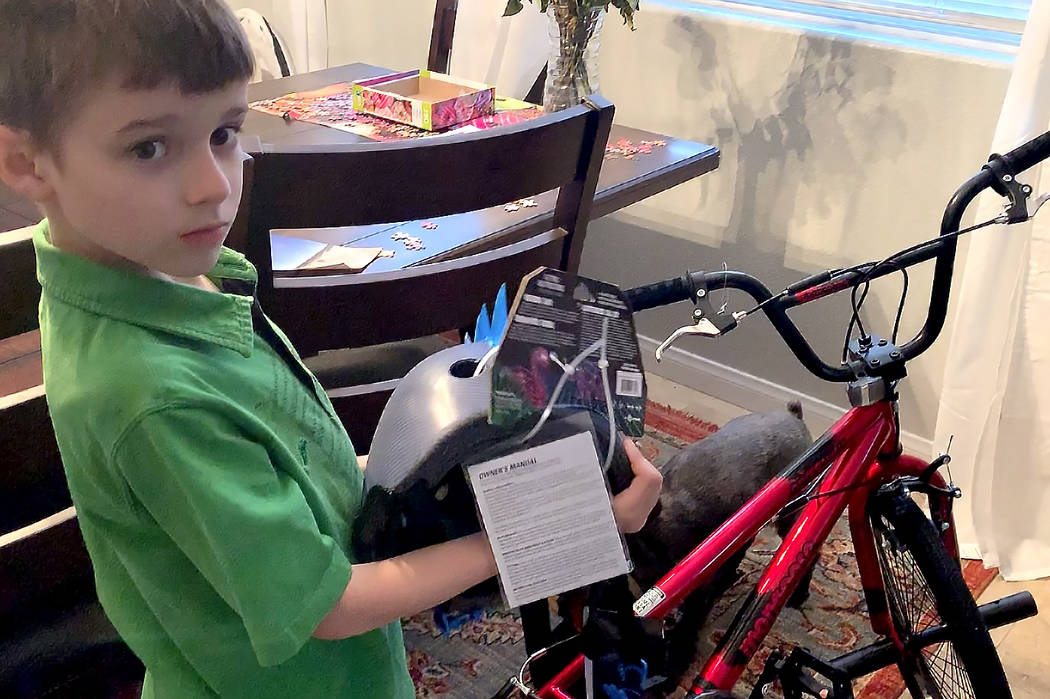 Spencer Powell, 8, shows the new bicycle and helmet he received from an anonymous donor after his accident. (Mat Lusheck/Las Vegas Review-Journal)