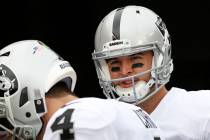 Oakland Raiders quarterback AJ McCarron, right, prepares to take the field during practice before an NFL football game, Sunday, Dec. 16, 2018, in Cincinnati. (AP Photo/Frank Victores)